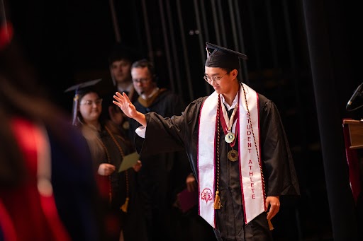 Shane Witzer, Ingles Award recipient, crossing stage at graduation.